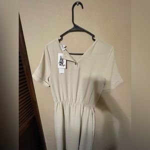 Small super simple tan dress with belt at the waist.